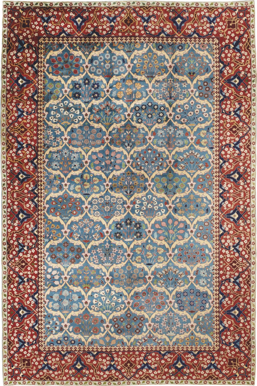 A PETAG Tabriz carpet, circa 1920: a sky-blue field worked in a single-plane lattice of flowering plants, framed by a deep red border of arabesques and a white-ground floral guard stripe