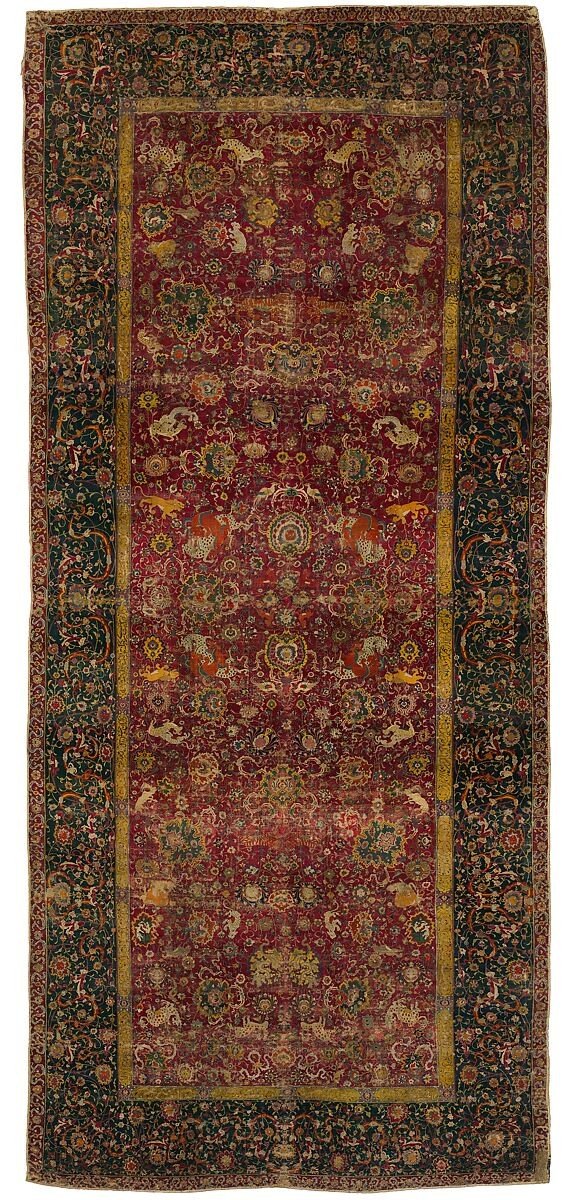 The Emperor&rsquo;s Carpet: a wine-red field of palmettes, cloud bands and animals within a deep green border.