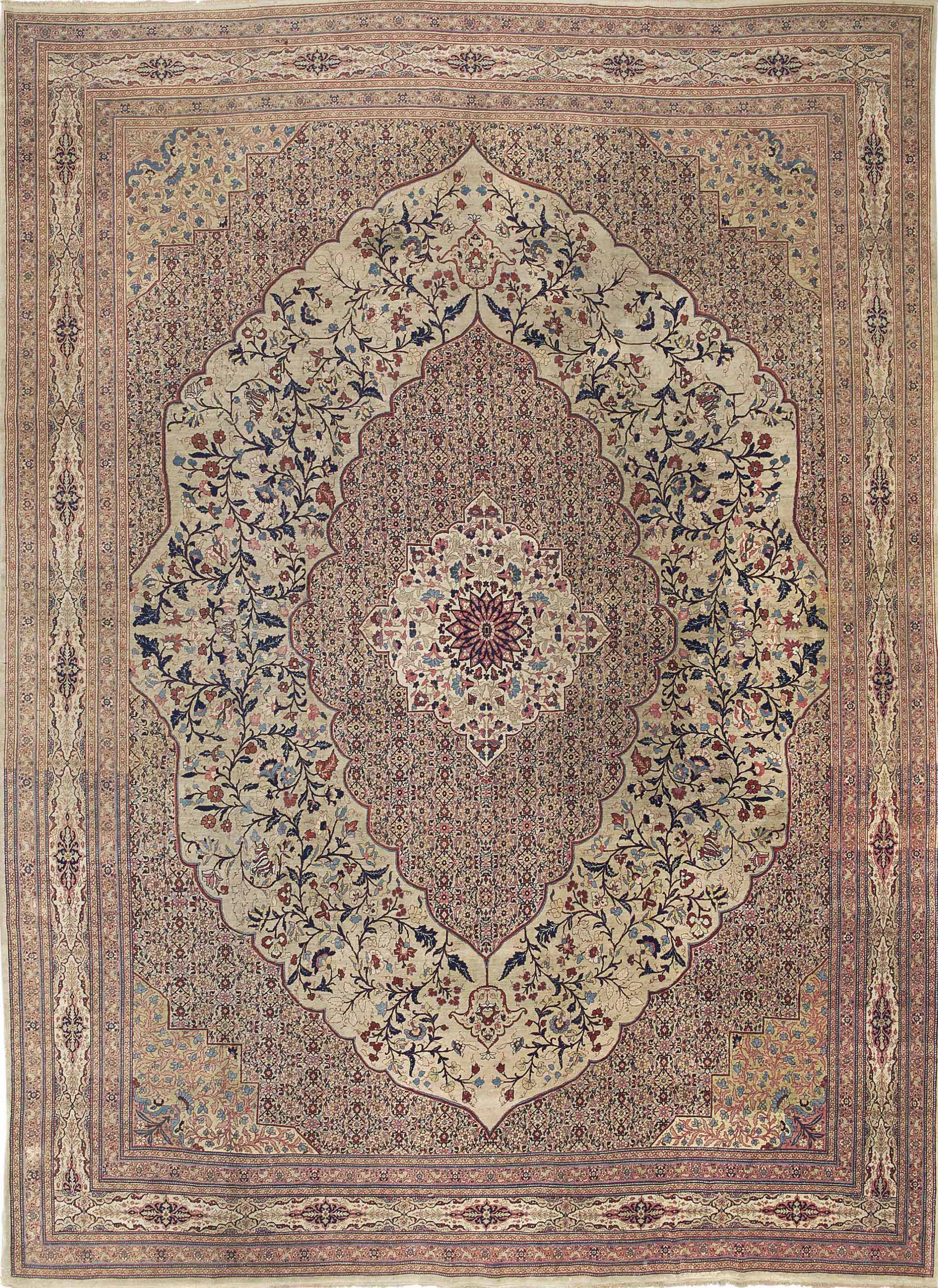 A fine Haji Jalili Tabriz carpet, north-west Persia, late nineteenth century, with a stepped ivory medallion and an allover field of delicate floral vinework on a soft café-au-lait ground, the blues used only as sparing accents