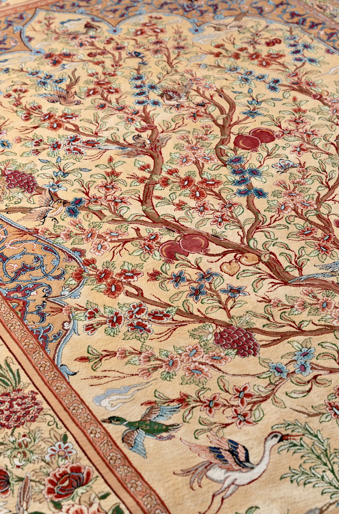 Close detail of the Tree of Life panel: branches running with blossom and fruit, including pomegranates, with songbirds among the leaves and a crane and duck below.