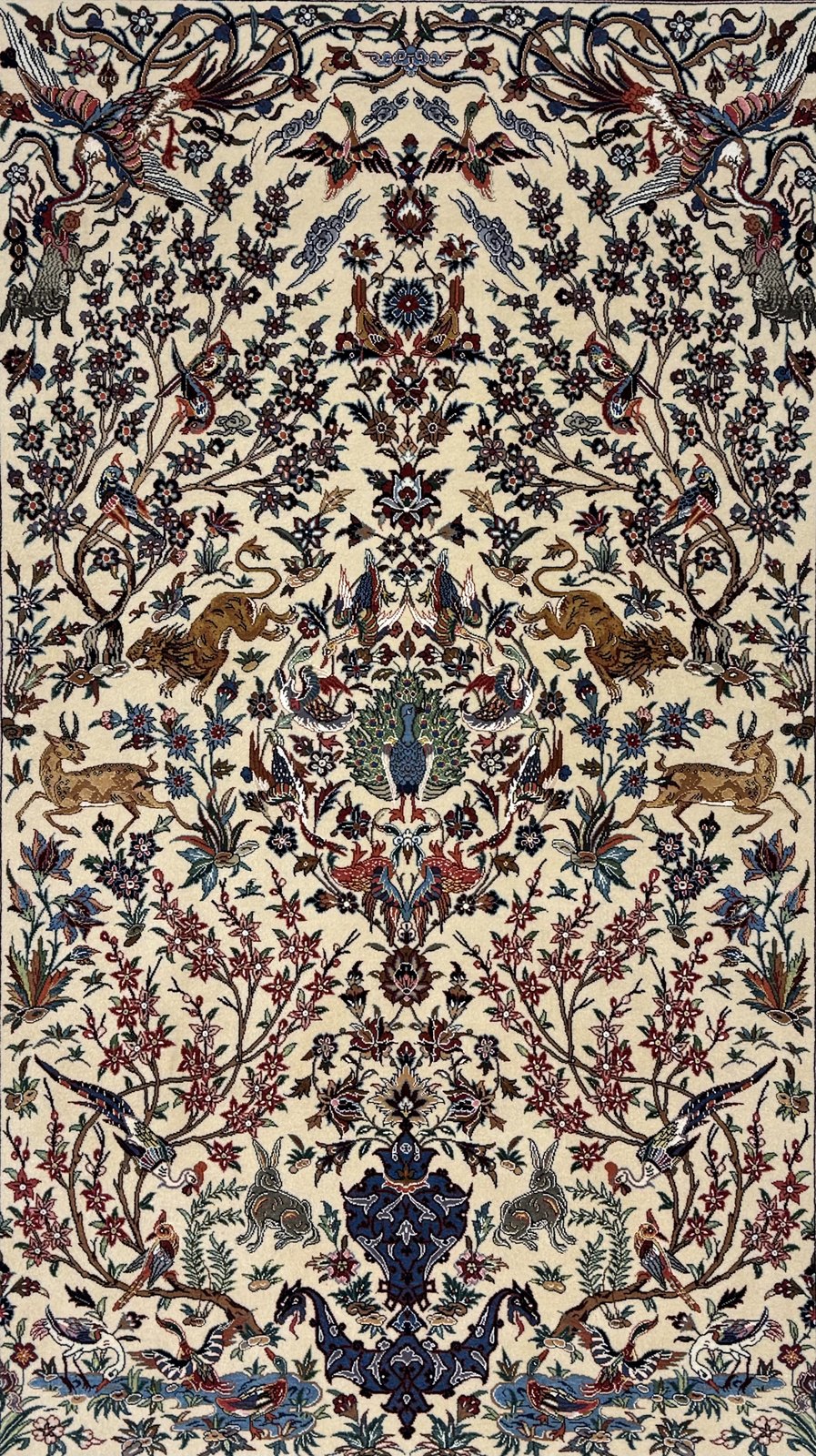 The full field of the Tree Pattern carpet, showing the central peacock, confronting tigers, leaping gazelles, hares and birds among the flowering vine.