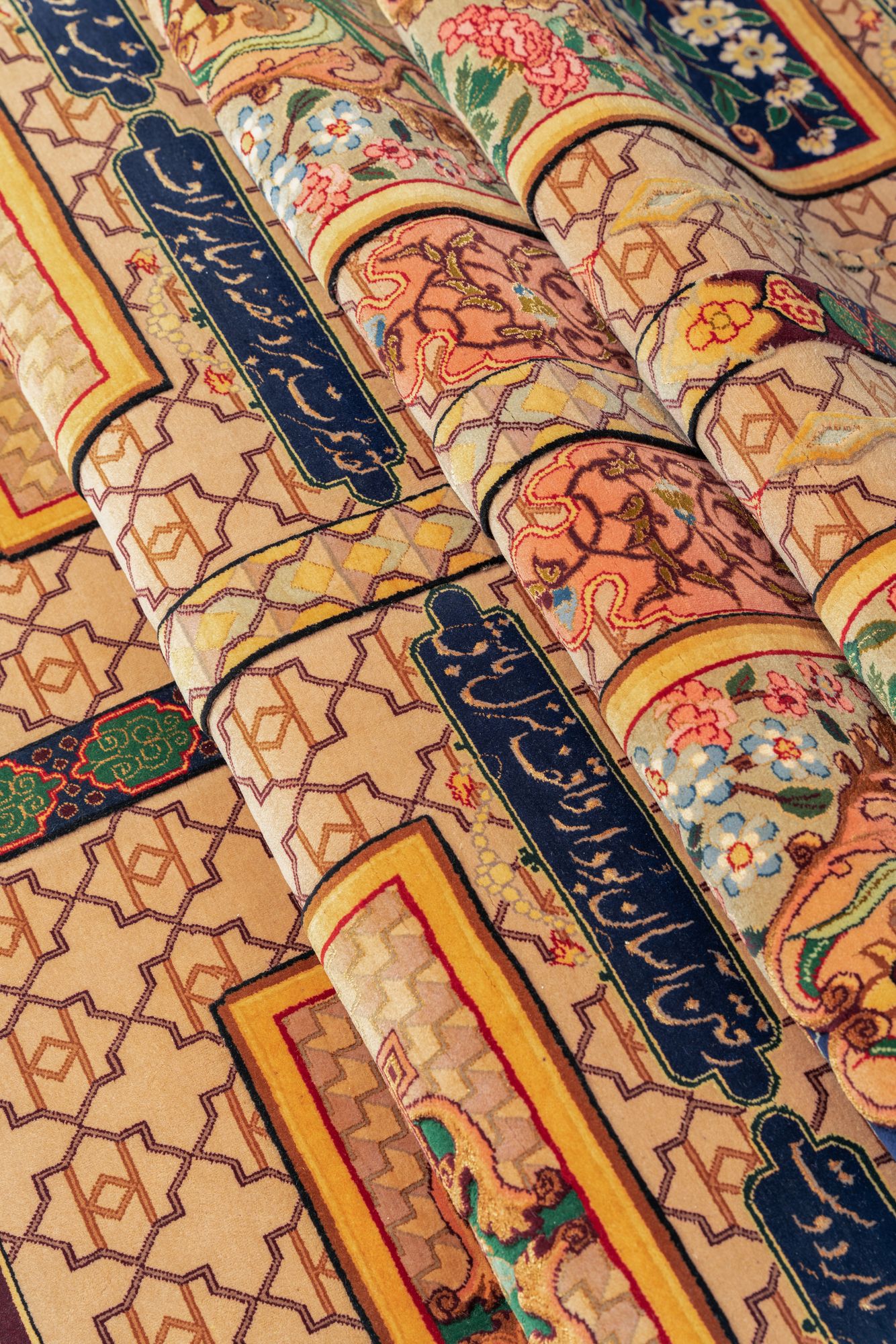 Detail of the woven Persian inscription cartouches and the silk highlights of the border, the gold-thread work catching the light.