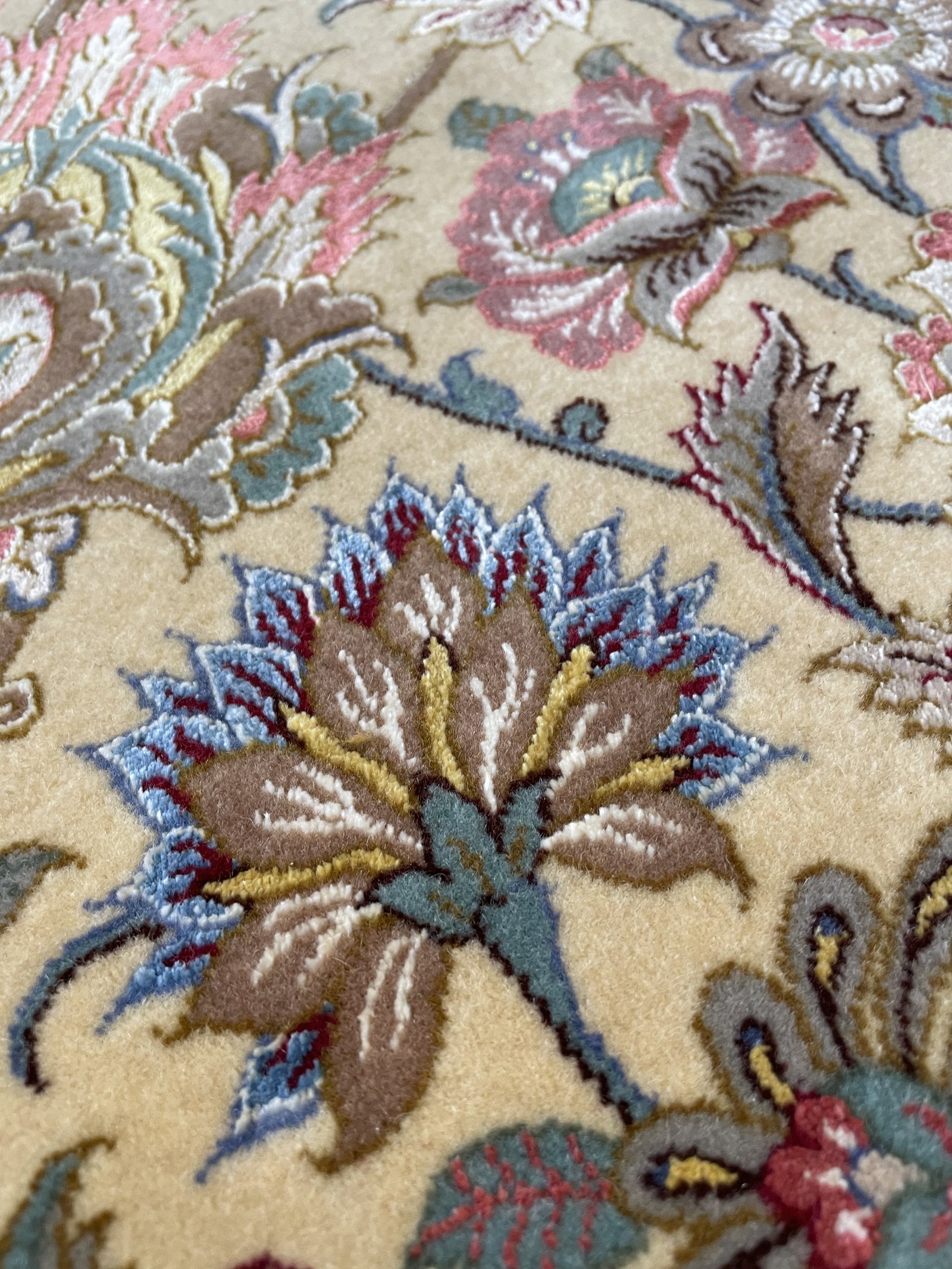 A single bloom of the field worked in lustrous silk pile, raised against the wool ground.