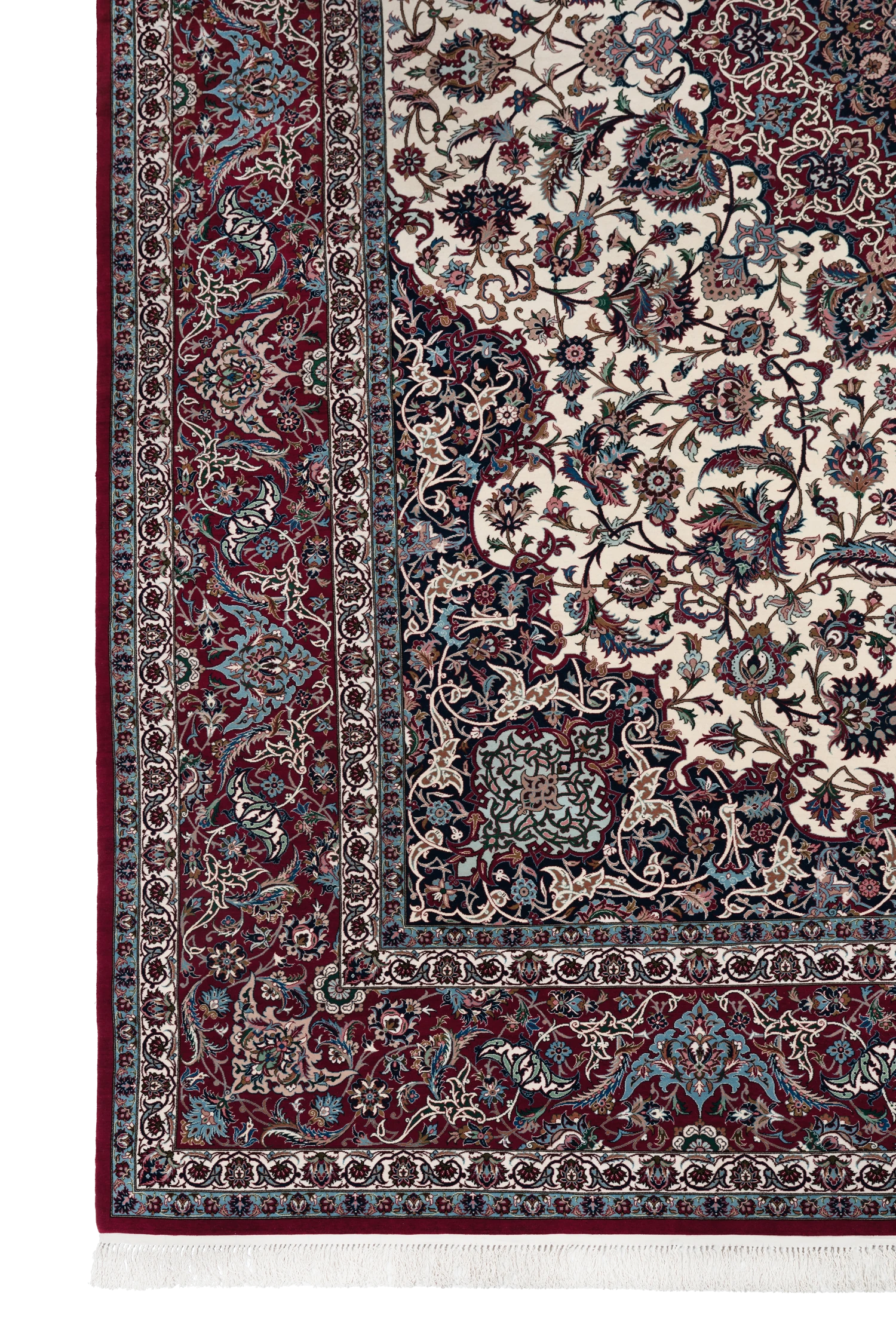 The corner of the carpet: the navy floral spandrel meeting the ivory field, the full border system, and the white silk fringe.