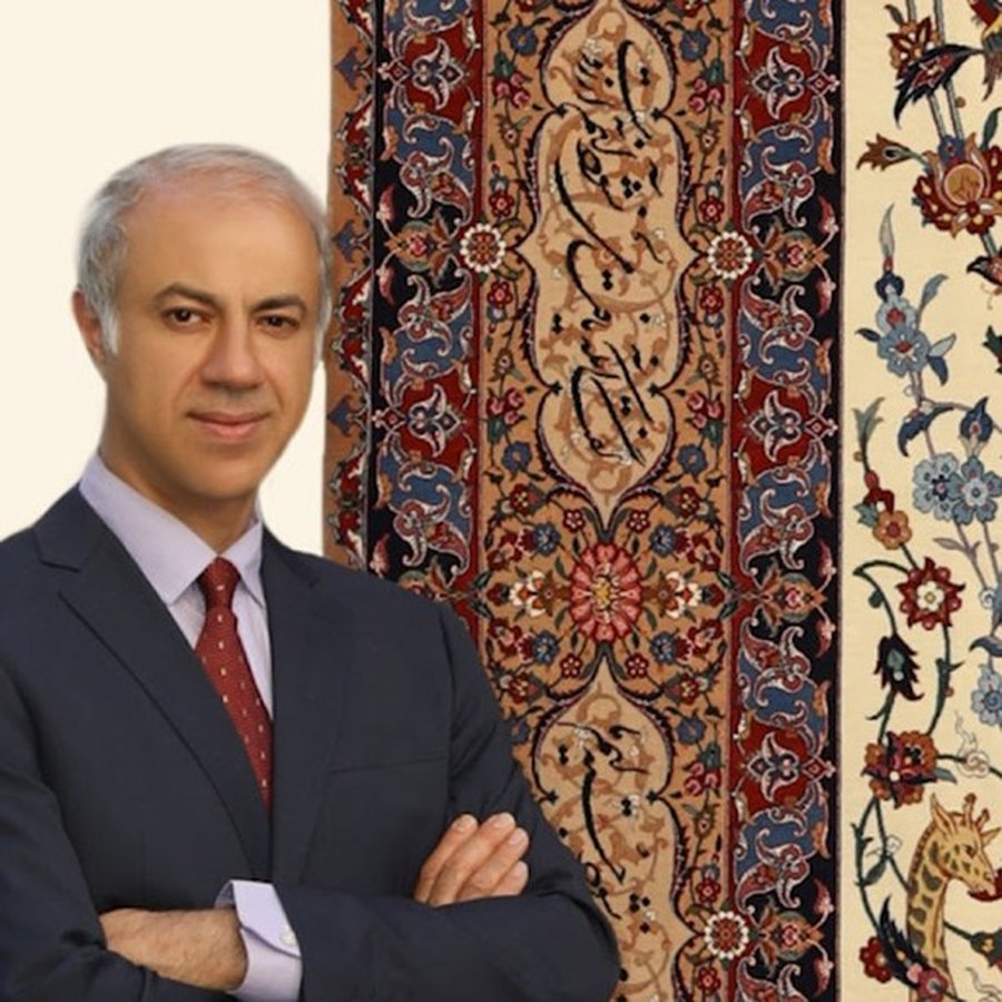 Karim Seirafian photographed beside one of his Isfahan carpets.
