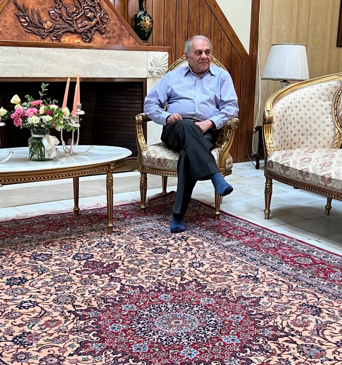 Ahmad Zojaji seated on one of his carpets.